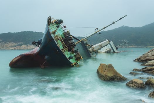 Shipwrecks in the sea with sunset background blue color tone