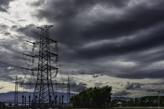 Power plant transmission line against dark ominous clouds