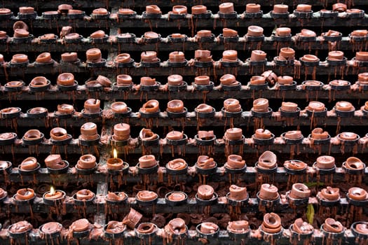 Lit and unlit red little candle offerings of people for their loved ones