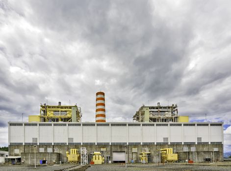 Old coal power plant in Asia shot against ominous dark clouds