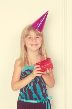 Girl 5 years with a birthday gift and cap