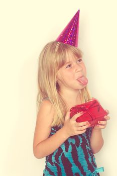 Girl 5 years with a birthday gift and cap