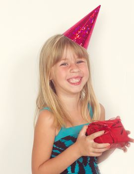 Girl 5 years with a birthday gift and cap