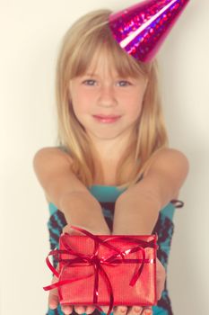 Girl 5 years with a birthday gift and cap