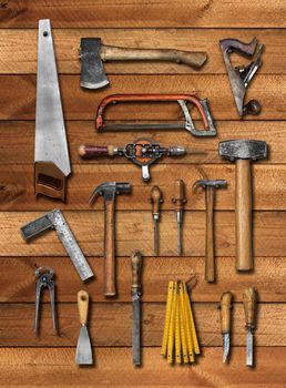 Old carpenter hand tools on wooden plank background