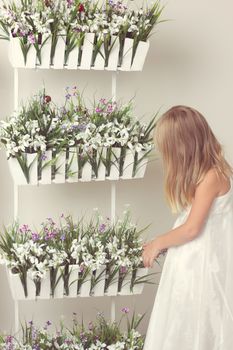 beautiful girl with summer flowers in the garden center