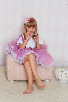 Little girl princess is sitting on chair