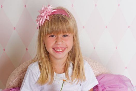 Little girl princess is sitting on chair