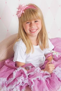 Little girl princess is sitting on chair