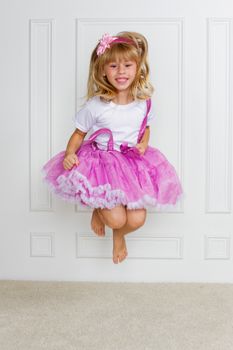 Jumping Excited Girl wearing beautiful dress on white