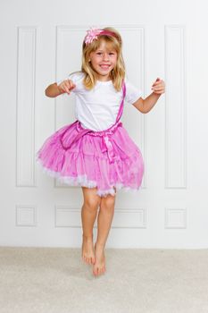 Jumping Excited Girl wearing beautiful dress on white