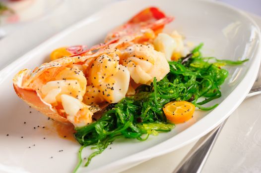 Prepared lobster and sea weed served on plates
