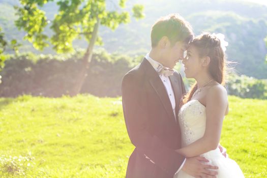 Bride and groom surrounding by natural golden sunlight