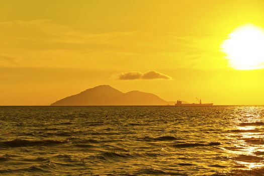 Cargo container ship sailing at the sunset