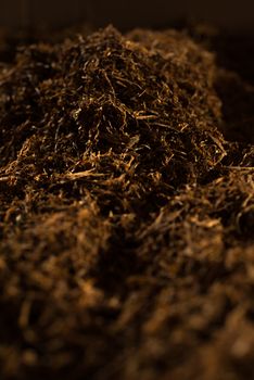 Fine cut tobacco background with hard light inside a cigarette production machine