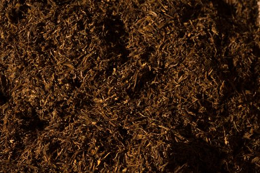 Fine cut tobacco background detail inside a cigarette production machine