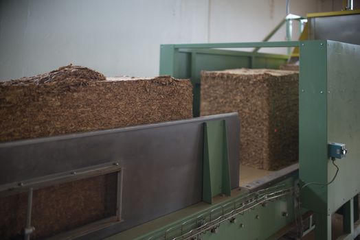 Bulk tobacco cubes inside a production line in a cigarette factory