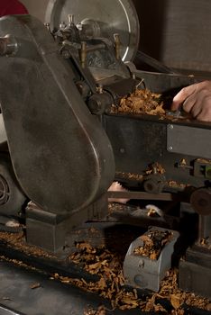 Tobacco cut in small scale machinery by a worker