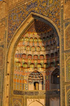Colorful wood carvings of Abdulaziz Khan Madrassah (Museum of Wood Carving Art) illuminated by the setting sun, Uzbekistan