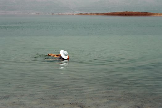 Woman in the water of the Dead sea Israel