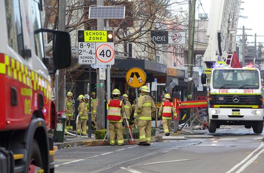 ROZELLE, AUSTRALIA - SEPTEMBER 4, 2014; A team of firemen and engineers at work after a shop explosion in Rozelle.
