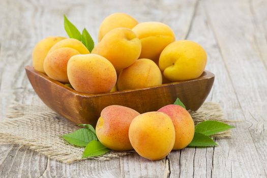 fresh apricots in a bowl on wooden background
