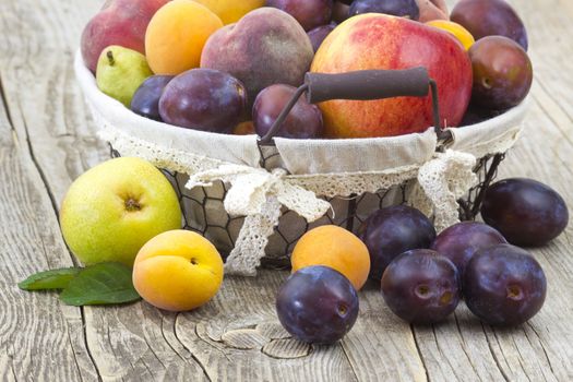 fresh fruits in a basket on wooden background