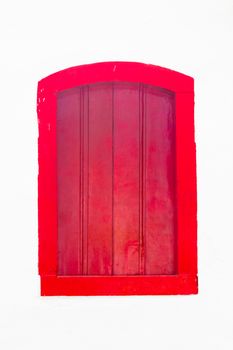 Decorative, colonial, red, vintage, window on a white wall in Paraty (or Parati), Brazil.