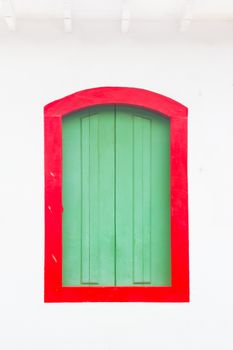 Decorative, colonial, colorful, vintage, window on a white wall in Paraty (or Parati), Brazil.