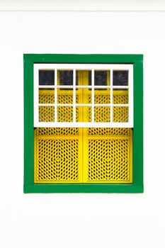 Decorative, colonial, green yellow, vintage, window on a white wall in Paraty (or Parati), Brazil.