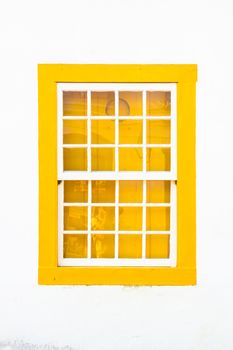 Decorative, colonial, yellow, vintage, window on a white wall in Paraty (or Parati), Brazil.