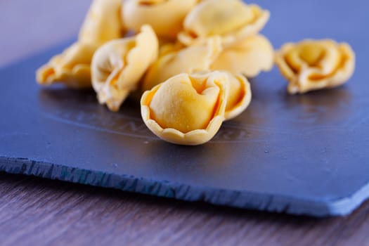 Agnolotti over black chopping board, close up