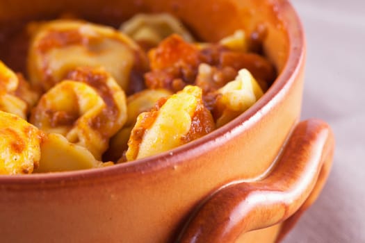 Agnolotti with tomato sauce in crock pot, close up