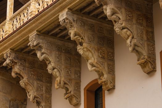 original corbel decoration in La Salina Palace courtyard with twisted carved bodies in Salamanca Spain