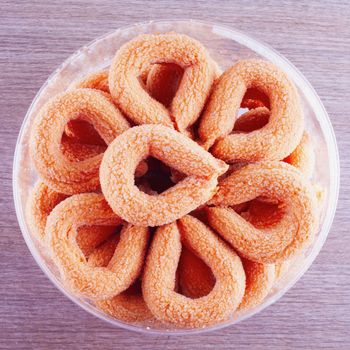 Torcetti with sugar in a circular box, over a wooden table
