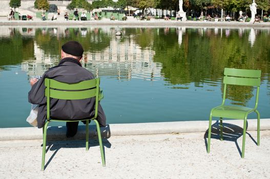 man reading in Tuileries garden in Paris