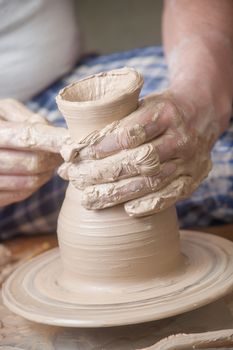 Hands of a potter, creating an earthen jar on the circle