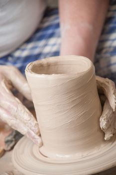 Hands of a potter, creating an earthen jar on the circle