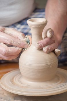 Hands of a potter, creating an earthen jar on the circle