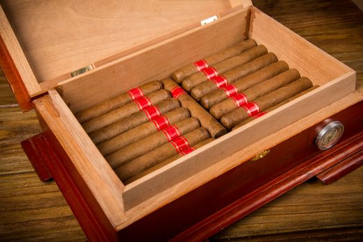 Cuban cigars and humidor on rustic wooden table