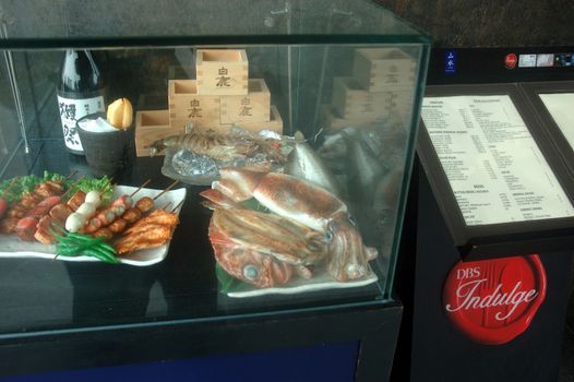 Singapore, Singapore - January 18, 2014: Replica of seafood cuisine made from plastic displayed within glass box.