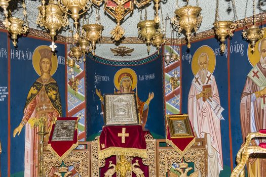 A picture of Virgin Mary with candles and pictures of other Saints