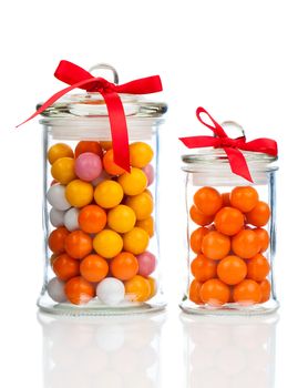 Colorful background of assorted Gumballs in  glass jar,  isolated over white background