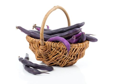 Red bean pods in wicker basket over white background