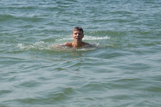 A boy swiming in water at the beach