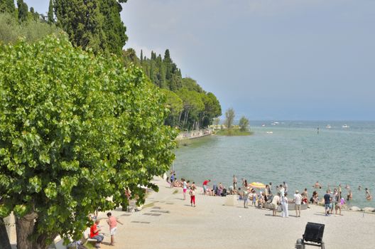 People bathing in the lake Garda in the village of Sirmione, Italy