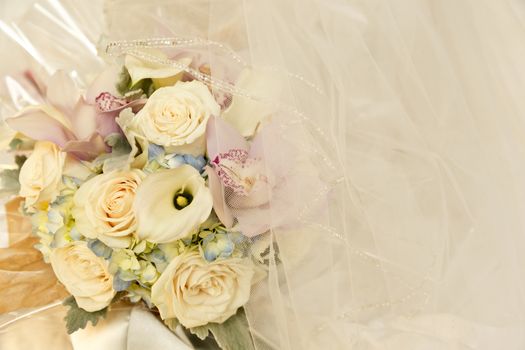 Wedding flowers in tones of ivory, pink and blue, placed with bridal veil 