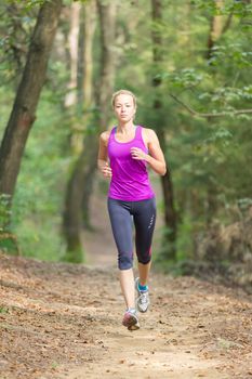 Pretty young girl runner in the forest.  Running woman. Female Runner Jogging during Outdoor Workout in a Nature. Beautiful fit Girl. Fitness model outdoors. Weight Loss. Healthy lifestyle. 