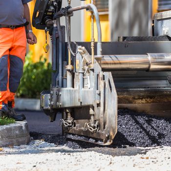 Construction workers during asphalting road works. Manual labor.