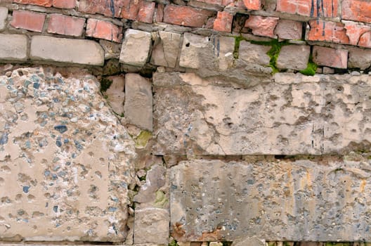 Old ruined concrete wall with red bricks
